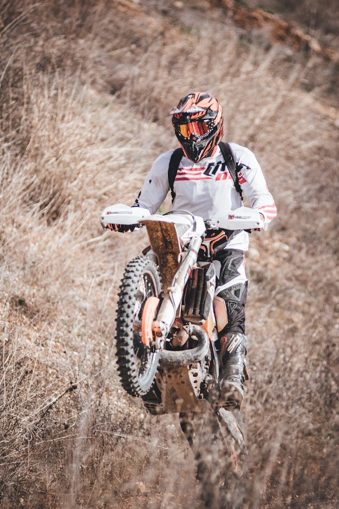 Person Riding White Dirt Bike Mid Air